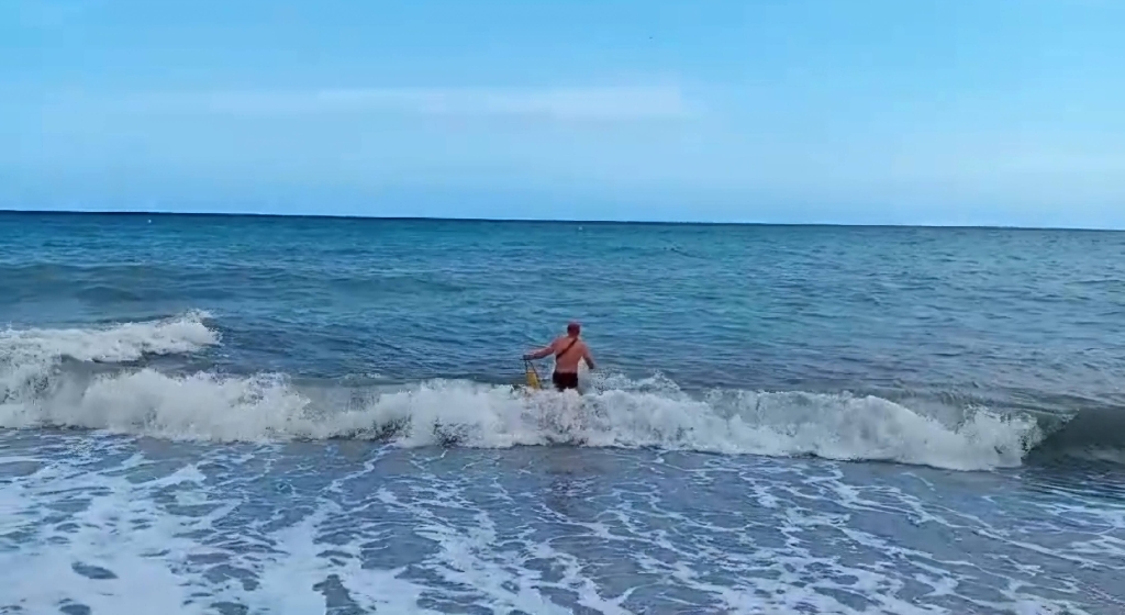 Un agent de la Policia Local de la Vila Joiosa rescata un banyista entre fort onatge del mar a la platja del Bol Nou